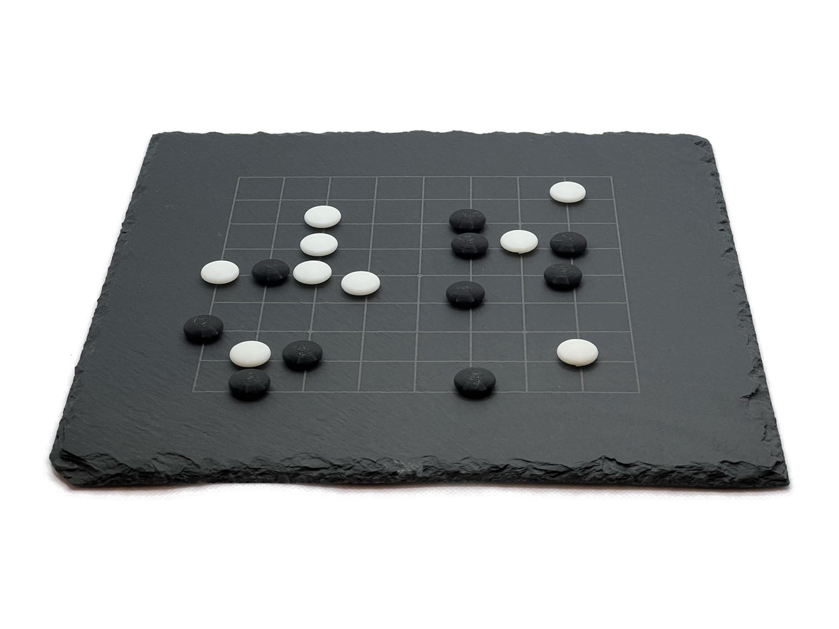 Baduk Spielbrett 9x9 Ansicht: Strategische Aufstellung der Steine auf dem gravierten 9x9 Raster.