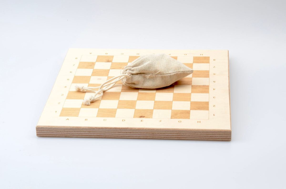 Zubehör für Holzschach: Praktischer Leinenbeutel zur Aufbewahrung der Figuren auf dem hellen Spielbrett.