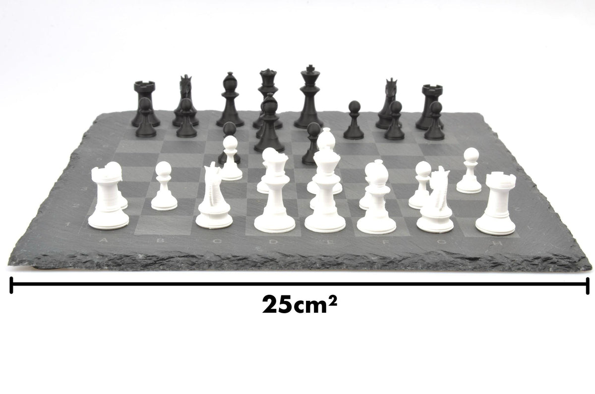 Maße des kompakten Schachspiels: 25 cm breites Brett aus Naturschiefer mit aufgestellten Figuren in Schwarz und Weiß.